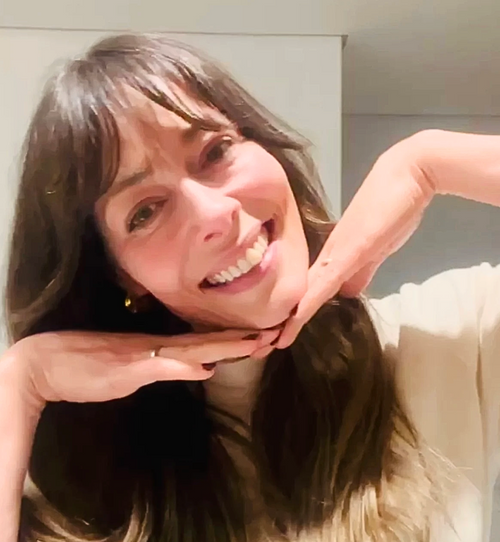Woman with long brown hair smiling at the camera