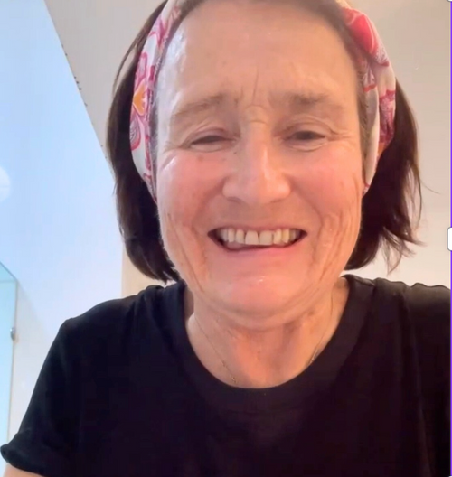 Person wearing a black shirt and a colorful headband with a light background
